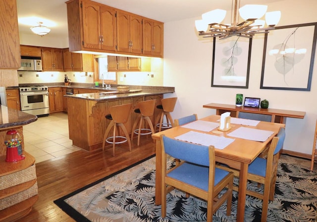 dining space featuring a chandelier, light hardwood / wood-style floors, and sink