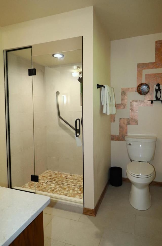 bathroom featuring vanity, a shower with shower door, toilet, and tile patterned floors