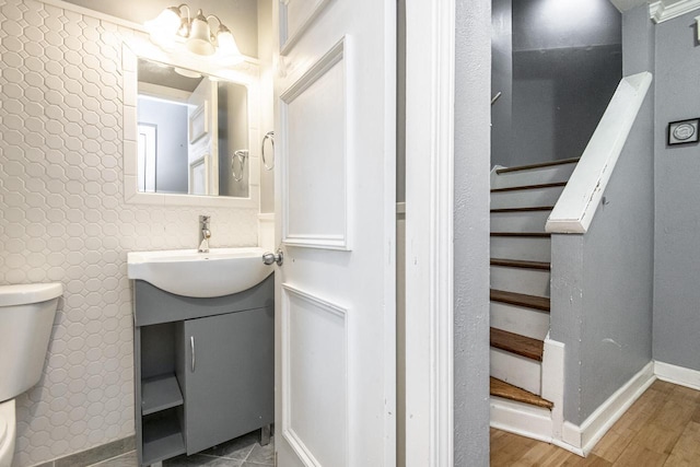 bathroom with vanity, toilet, hardwood / wood-style floors, and a chandelier