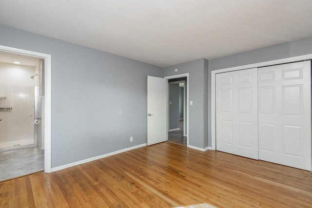 unfurnished bedroom with ensuite bath, a closet, and light hardwood / wood-style floors