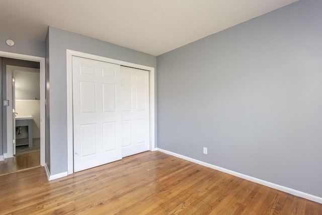 unfurnished bedroom with light hardwood / wood-style flooring and a closet