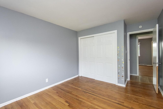 unfurnished bedroom featuring hardwood / wood-style flooring and a closet