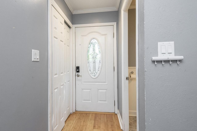 entryway with crown molding and light hardwood / wood-style flooring