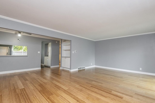 spare room with crown molding and light hardwood / wood-style floors