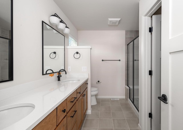 bathroom with tile patterned floors, vanity, toilet, and walk in shower