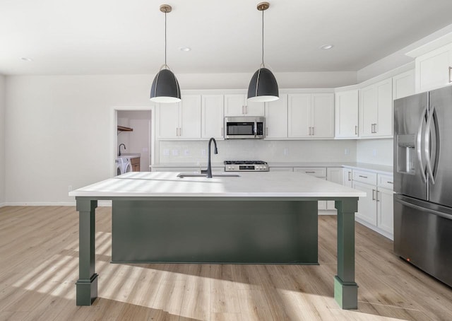 kitchen featuring independent washer and dryer, white cabinetry, sink, and appliances with stainless steel finishes