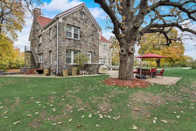 exterior space featuring a front lawn and a patio