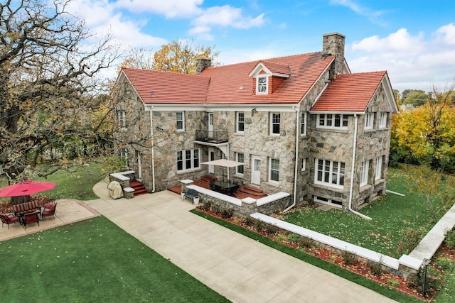 back of house with a lawn and a patio