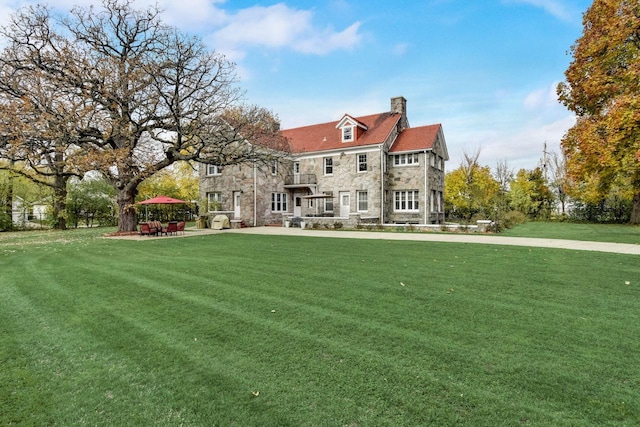 rear view of property featuring a lawn