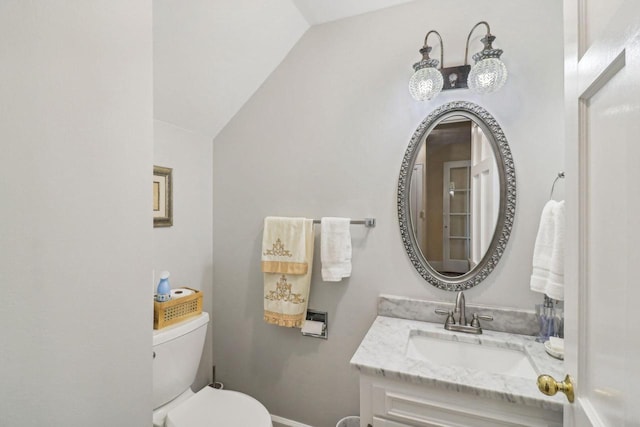 bathroom featuring lofted ceiling, vanity, and toilet