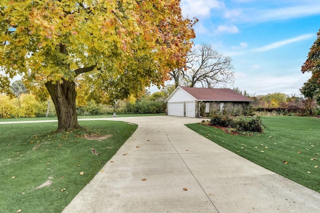 view of front of home featuring a front lawn, a garage, and an outdoor structure