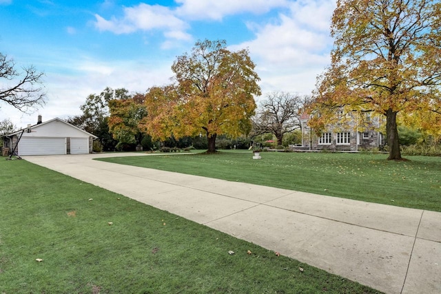 view of front facade with a garage, a front yard, and an outbuilding