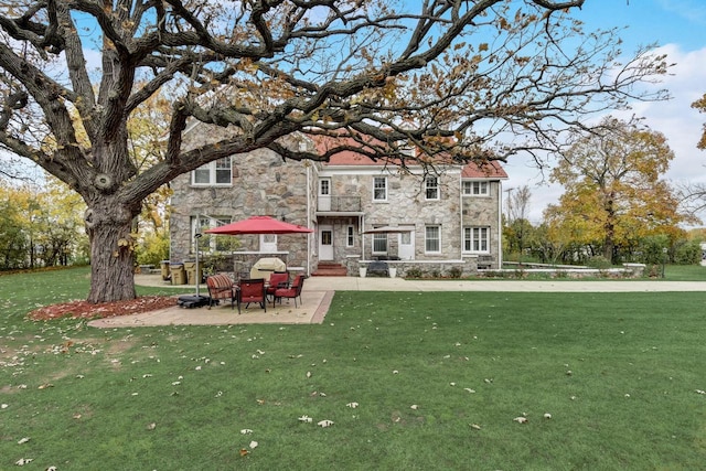 rear view of house featuring a yard and a patio area