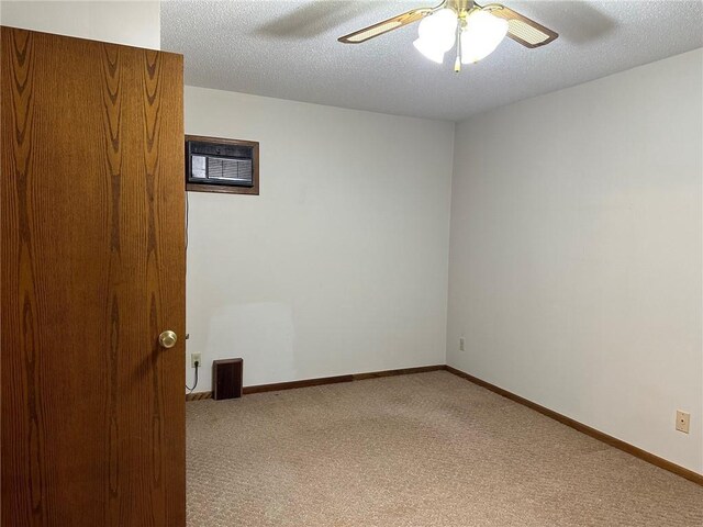 carpeted spare room with a textured ceiling and ceiling fan