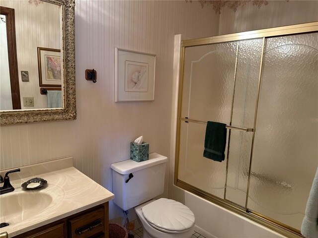 full bathroom with shower / bath combination with glass door, vanity, toilet, and tile patterned flooring