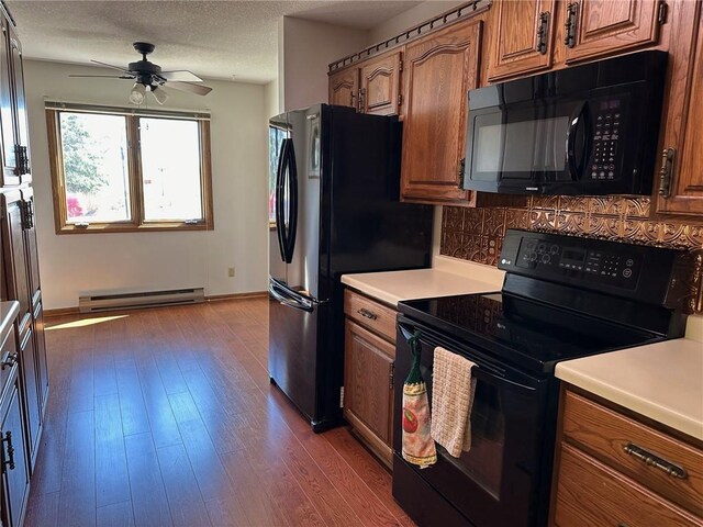 kitchen with black appliances, a baseboard radiator, dark wood-type flooring, ceiling fan, and decorative backsplash