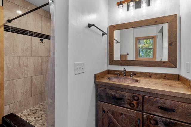 bathroom featuring a tile shower and vanity