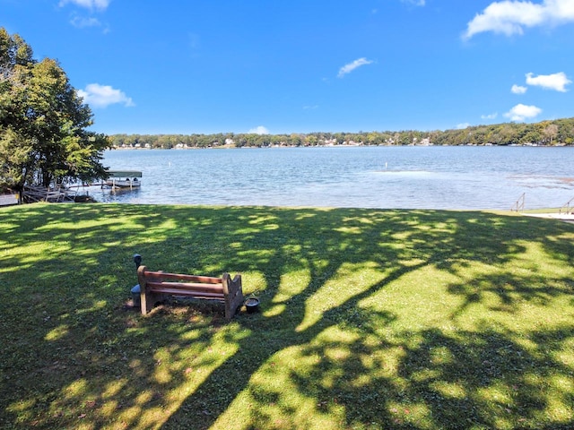 exterior space featuring a lawn and a water view