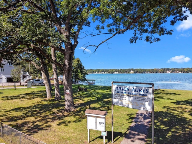 view of community featuring a lawn and a water view