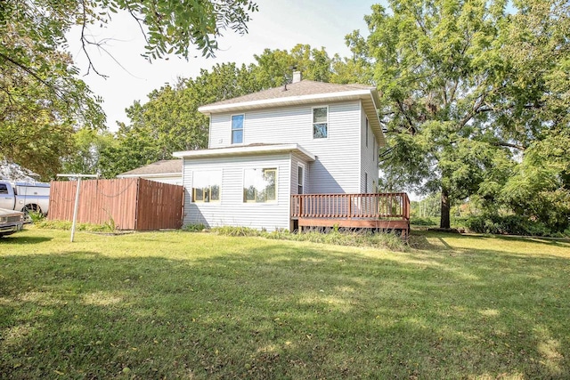 back of house featuring a wooden deck and a yard