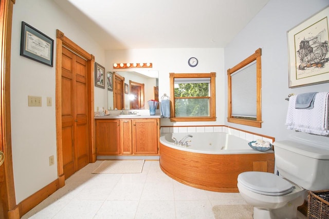 bathroom with tile patterned floors, a bath, vanity, and toilet