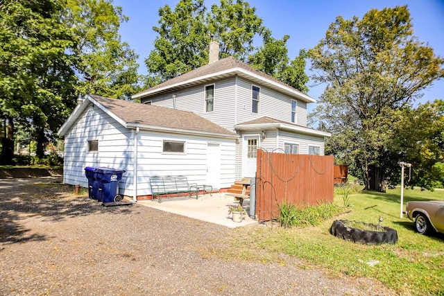 back of property with a lawn and a patio