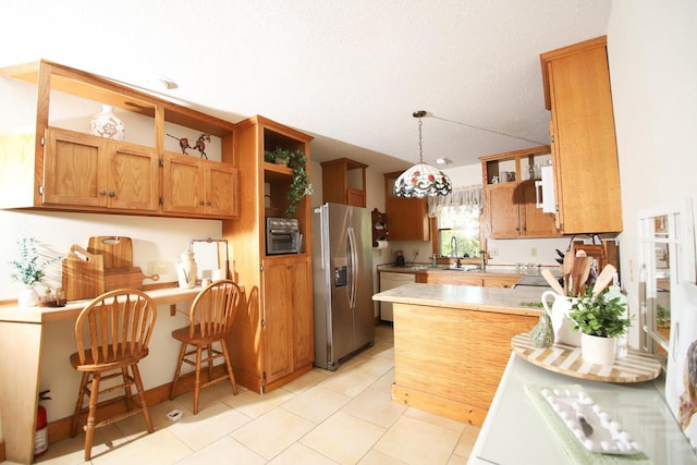 kitchen with stainless steel fridge, kitchen peninsula, light tile patterned floors, white dishwasher, and decorative light fixtures