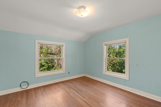 spare room with vaulted ceiling and hardwood / wood-style floors