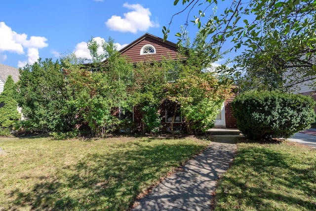 view of property hidden behind natural elements featuring a front lawn