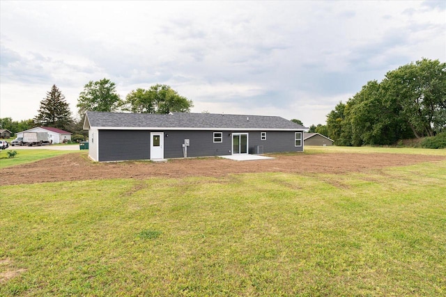 rear view of property with a lawn and a patio