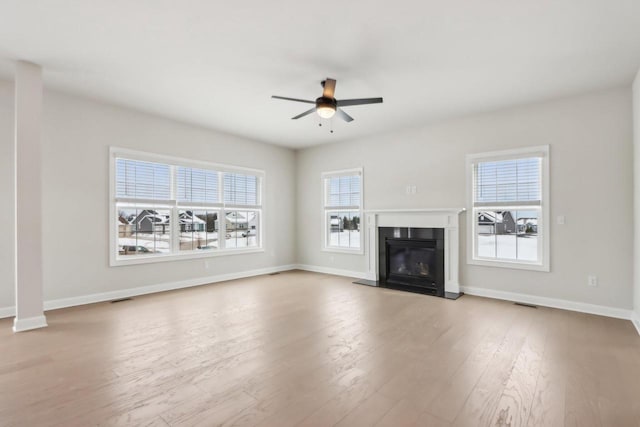 521 N Stone Ridge Dr, Lake Geneva, WI 53147 - unfurnished living room featuring ceiling fan, wood finished floors, and a glass covered fireplace