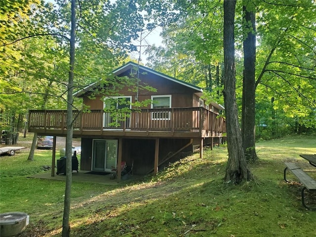 rear view of house with a lawn and a wooden deck