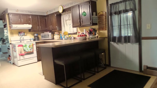 kitchen with dark brown cabinetry, white appliances, a kitchen bar, and kitchen peninsula