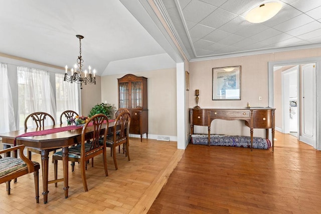 3790 Pau Ko Tuk Ln, Oshkosh, WI 54902 - dining space with a chandelier, crown molding, baseboards, and light wood-style flooring