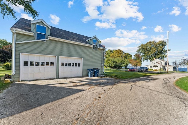 3790 Pau Ko Tuk Ln, Oshkosh, WI 54902 - view of property exterior featuring a garage, asphalt driveway, and roof with shingles