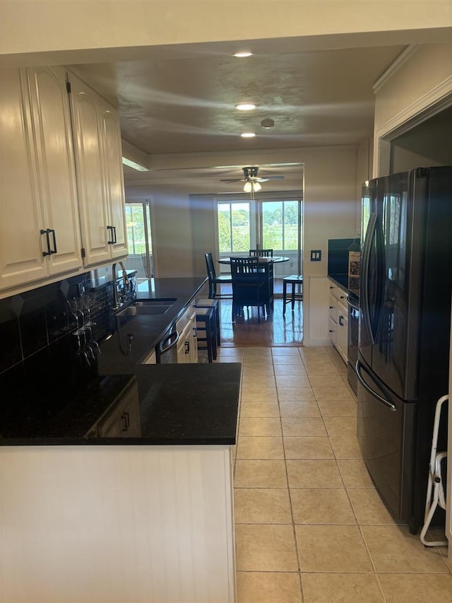 kitchen featuring light tile patterned flooring, tasteful backsplash, sink, kitchen peninsula, and black fridge