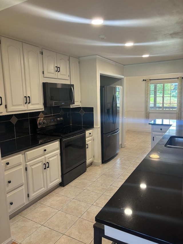 kitchen featuring backsplash, white cabinets, and black appliances