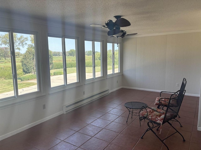 unfurnished sunroom with ceiling fan, a baseboard radiator, and a healthy amount of sunlight