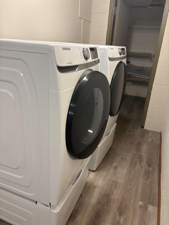 laundry area with hardwood / wood-style flooring and washer and clothes dryer