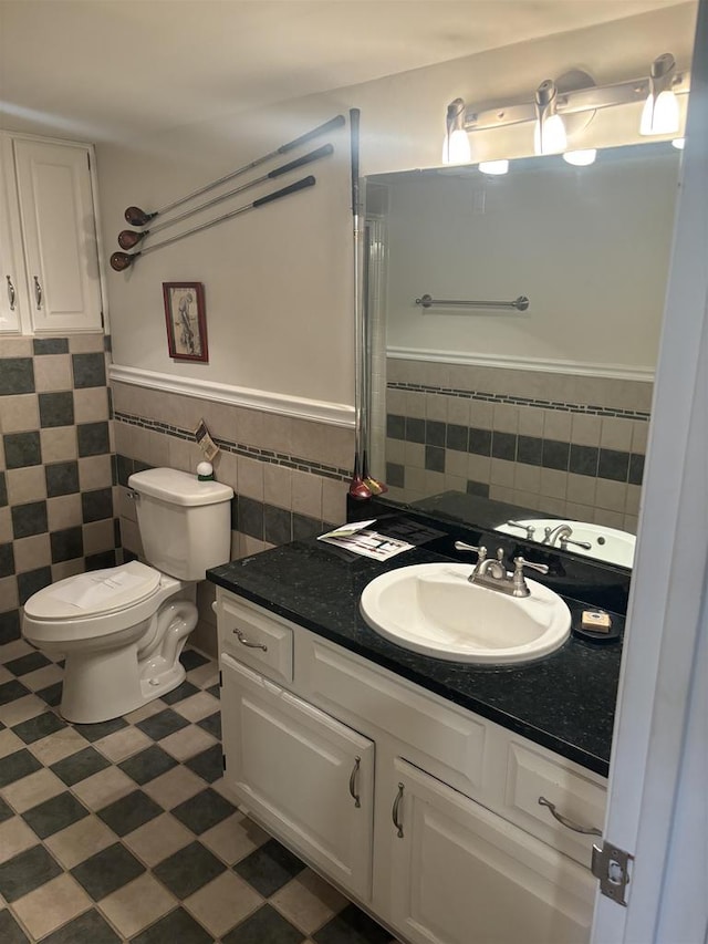 bathroom featuring tile walls, vanity, and toilet