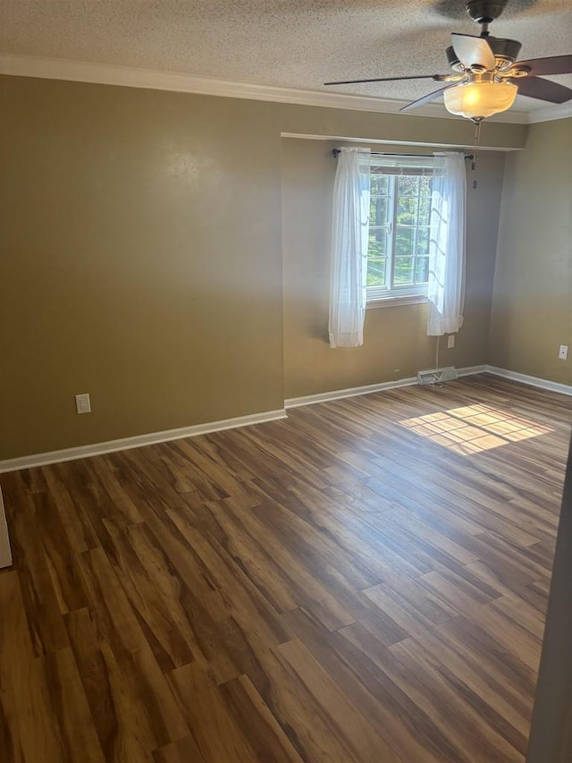 spare room with dark wood-type flooring, crown molding, and a textured ceiling