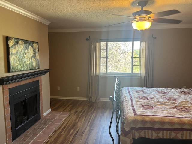 bedroom with dark hardwood / wood-style floors, a fireplace, ornamental molding, ceiling fan, and a textured ceiling