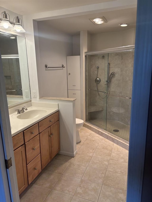 bathroom featuring vanity, an enclosed shower, tile patterned floors, and toilet