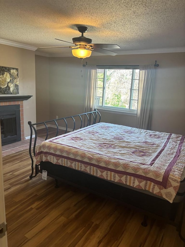 bedroom featuring crown molding, a textured ceiling, wood-type flooring, and ceiling fan