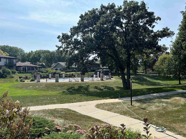 view of community featuring a pool and a lawn