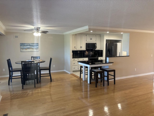 kitchen featuring black fridge with ice dispenser, tasteful backsplash, white cabinetry, a textured ceiling, and range with electric stovetop