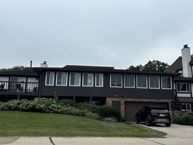 back of house featuring a garage and a yard