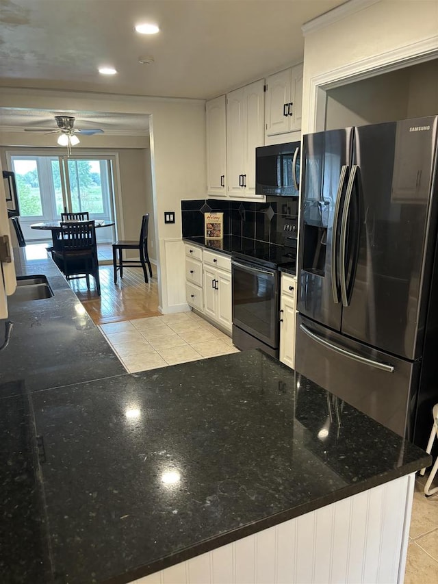 kitchen featuring fridge with ice dispenser, black electric range oven, white cabinetry, and light tile patterned floors