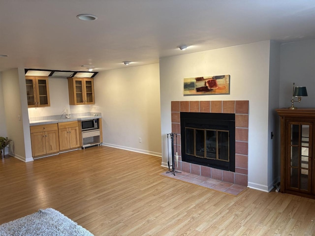 living room featuring sink, a fireplace, and light hardwood / wood-style floors