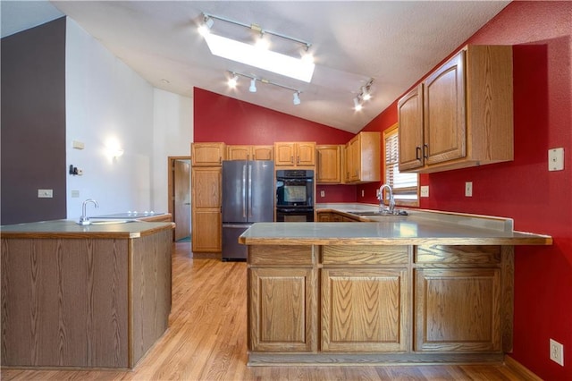 9018N Anderson Rd, Hayward, WI 54843 - kitchen with freestanding refrigerator, track lighting, a peninsula, a sink, and lofted ceiling